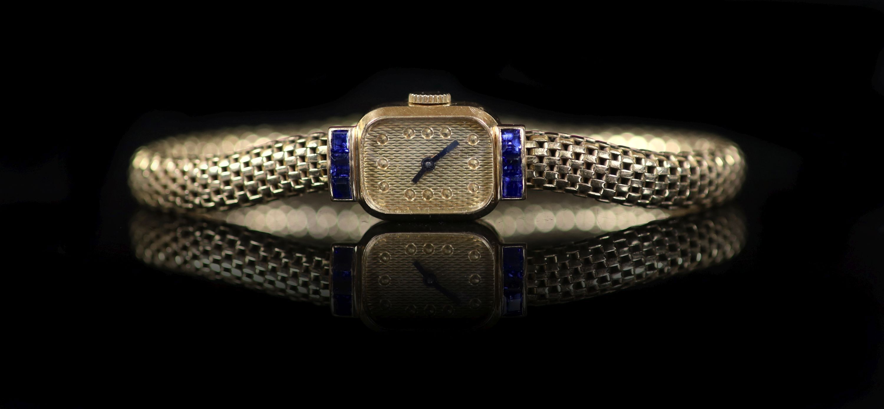 A lady's mid 20th century French Boucheron 18ct gold and six stone sapphire set manual wind cocktail watch, on an integral 18ct gold 'cage link' bracelet